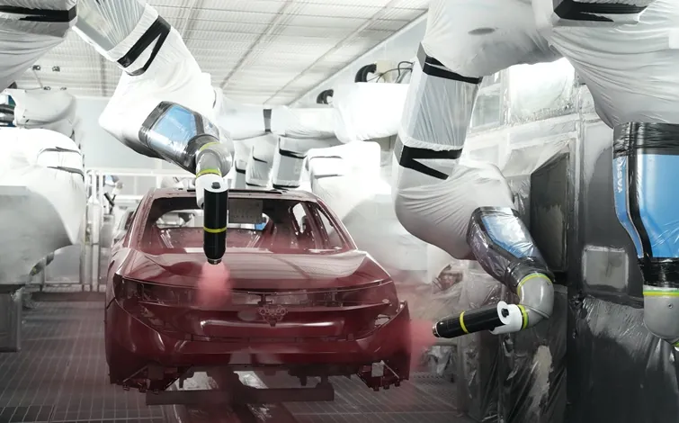 At the paint shop of the Tochigi plant, a robotic arm is evenly spraying red paint onto the body of a Nissan Leaf.