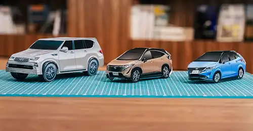 Three paper cars on display