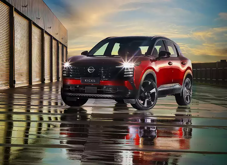 Nissan Kicks estacionado em frente a box de pista de corrida, após chuva e com dia acabando
