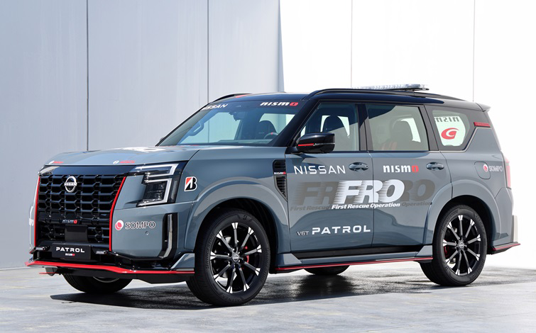 新型「パトロール NISMO」が屋外の白い建物の前に停まり、左前方を向いている様子を示す画像。グレーの車体に赤い差し色があり、フロントドア付近に「FRO」の文字が大きく表示されている。車両の前面から左側面が見える構図。