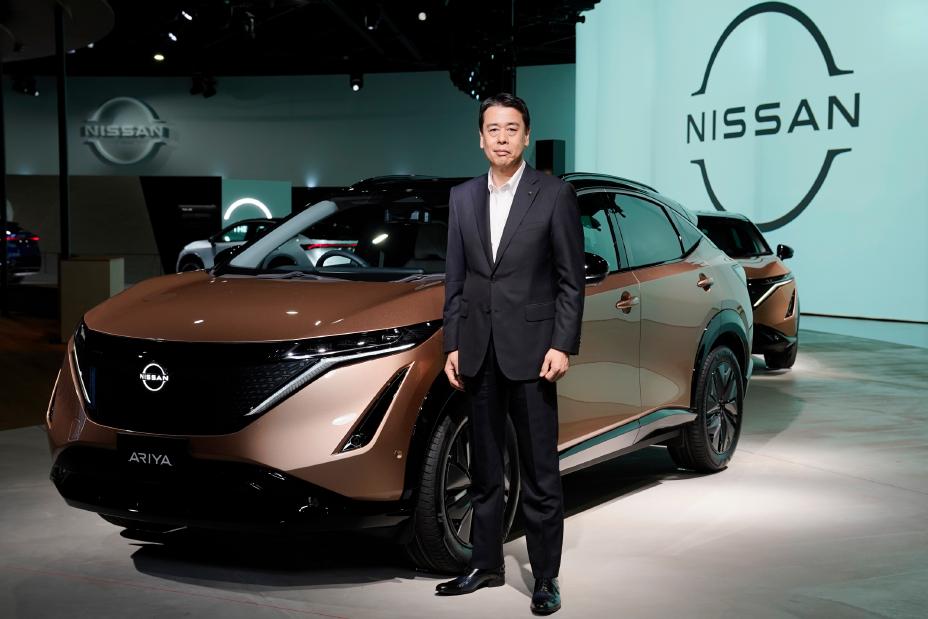 Um homem posando na frente de um carro no palco