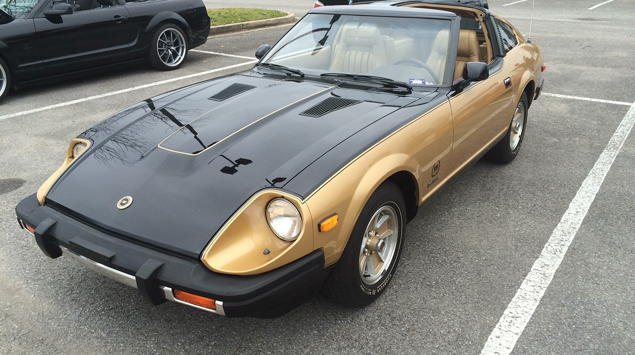 Nissan Z painted with black and gold parked in a parking lot.