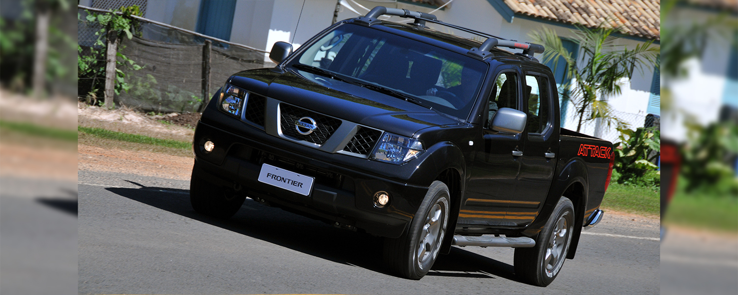 A black Nissan Frontier driving down the road