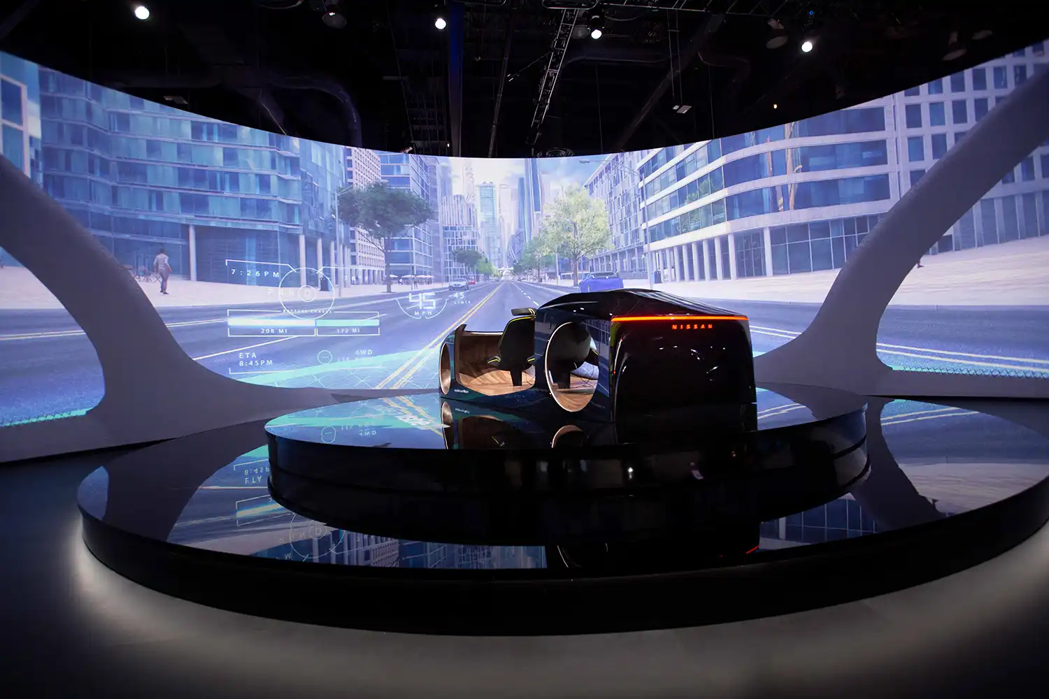 Un coche futurista estacionado en una sala de exposición frente a una pantalla con una calle de la ciudad.