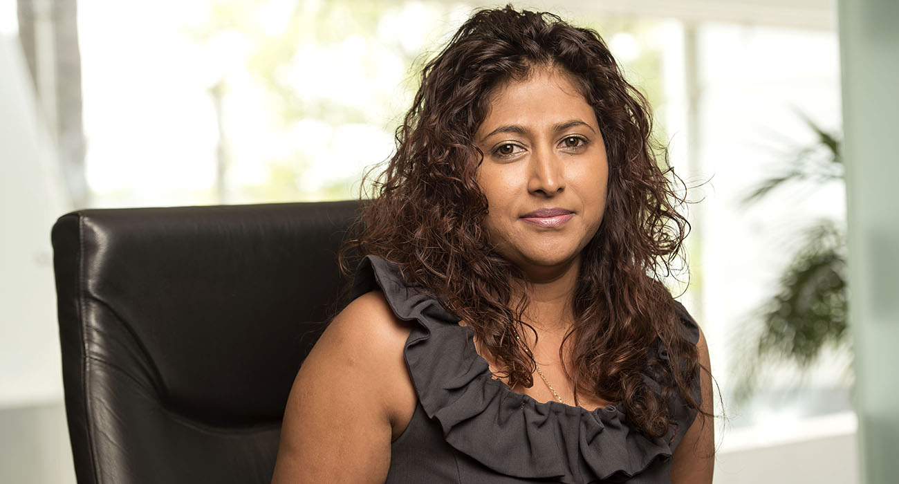 Nancy Moodley posing for a photo while sitting in a chair