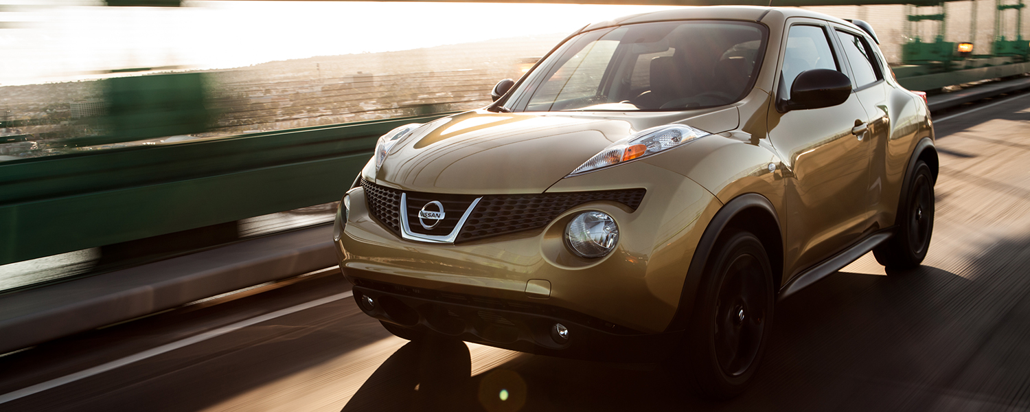 A gold Nissan Juke driving towards the camera